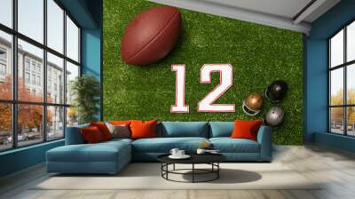 American football ball, number twelve and little helmets on green grass background. American football decoration Wall mural