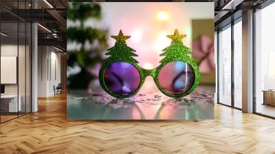 Christmas tree glasses and candy cane confetti against christmas decoration. Christmas tree glasses against fairy light. Christmas decoration Wall mural