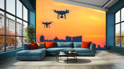 Two modern Remote Control Air Drones Fly with action cameras in dramatic sunset sky. Cityscape silhouette in the background. Modern technologies. Kiev, Ukraine. Travel, hobby, inspiration. Copy space Wall mural