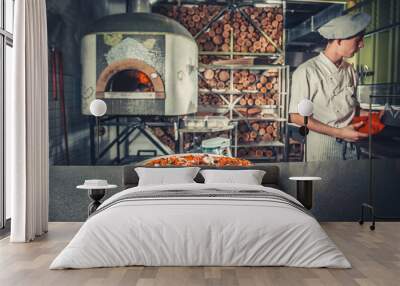 young male cook cooked pizza in restaurant Wall mural