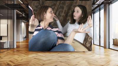 Mother and daughter in living room arguing and holding tablet Wall mural