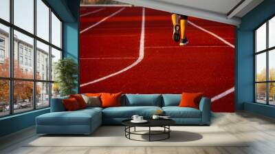 Red running track with runner's feet. Sport stadium for run. Wall mural