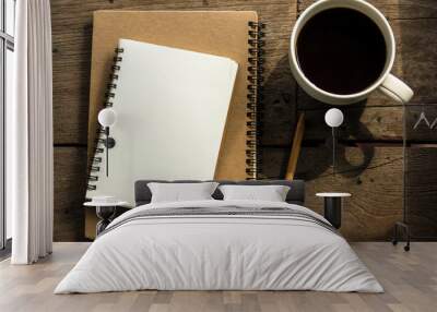 top view of blank notebook with white coffee, laptop and with natural light on wooden table. Wall mural