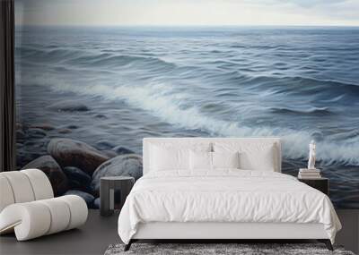 A rocky shoreline with smooth stones and gentle waves. Wall mural