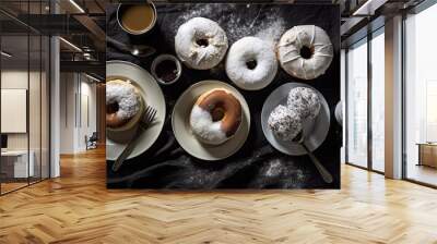 some doughs and coffee on a black table with white powder sprinng around them to make it look like they're Wall mural