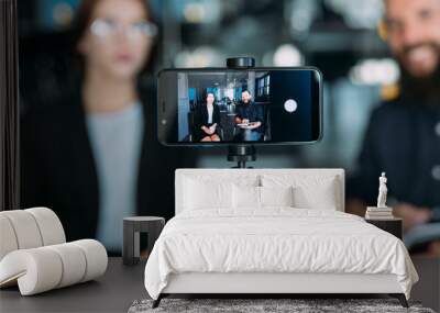 business man and woman shooting video using smartphone on tripod. coaching workshop Wall mural