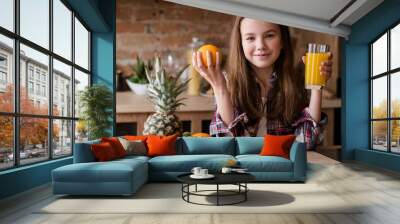 child healthy food and balanced nutrition. fresh orange juice and fruit breakfast. little girl in the kitchen ready to have a wholesome morning meal Wall mural