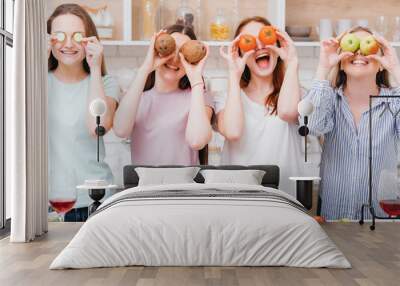 Dieting together. Healthy nutrition. Organic cooking. Excited young females posing with foods covering eyes. Wall mural