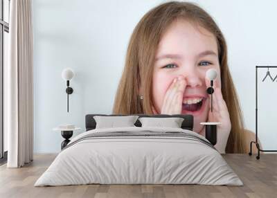 emotion face. child cup her hands to mouth crying out loud. kid yelling as if in megaphone. little girl portrait on white background. mood feelings personality and facial expression concept Wall mural