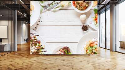 Food buffet top view. Restaurant table full of dishes. Selection of plates on white background Wall mural