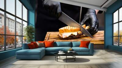 Grill restaurant. Cropped shot of chef using knife to cut smoked turkey breast sandwich on wooden board. Wall mural