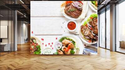 Grilled meat meals on table flat lay. Top view on assortment of bbq snacks. Summer foods barbecue dishes buffet. Wall mural