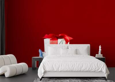 Holiday presents. Christmas covid-19. Safety delivery. New Year 2021. Hands in medicine gloves holding wrapped gifts taped ruby ribbon isolated on red copy space. Wall mural