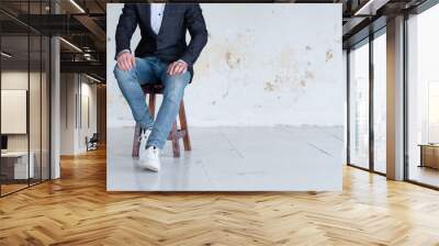 man in jacket and jeans sitting on a chair. confident business trainer or entrepreneur. smart casual Wall mural