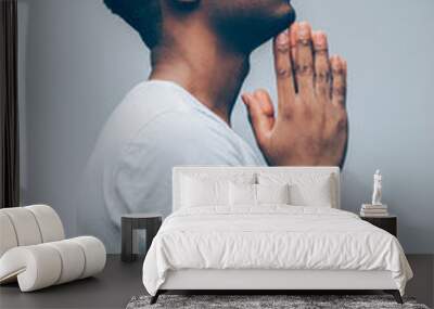 Religion and faith. Side view of afroamerican guy praying God, hoping for better. Man asking for good luck, success, forgiveness. Wall mural