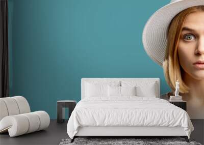 Summer holiday. Canceled vacation. Surprised blonde woman in white hat looking at camera isolated on blue copy space. Travel offer. Advertising background Wall mural