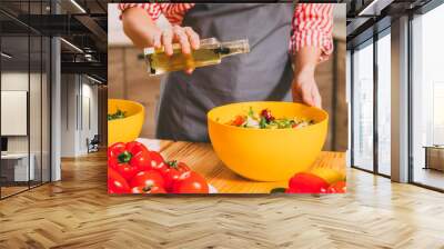 Vegetarian lifestyle. Cropped shot of woman cooking, dressing vegetable salad with organic olive oil. Wall mural