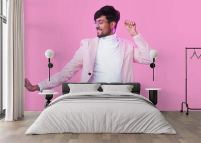 Winner dance. Party joy. Success celebration. Neon light happy relaxed guy in glasses stylish suit enjoying fun movements isolated on pink empty space background. Wall mural