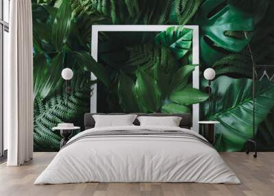 Creative flat lay with tropical leaves and white frame. Minimal jungle background. Nature concept. Wall mural