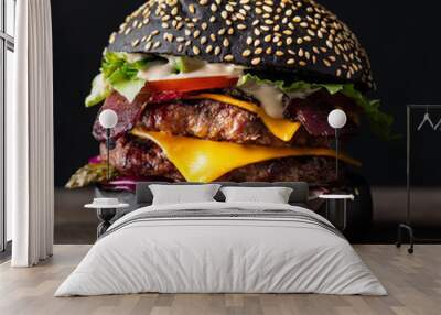 Fresh tasty burger with black bun and double beef patty on a black background. Wall mural