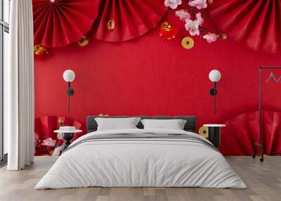 Set the festive mood with Chinese New Year decorations. Top view photo of gold dragon, red paper fans, traditional coins, sakura bloom on red background with advert area Wall mural