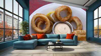 Deep fried seafood. Top view of delicious fried squid rings with lemon and a dipping sauce in a white bowl.	 Wall mural