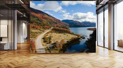 Fall colors. Aerial view of the highway besides the lake and across the mountains and forest in autumn. Wall mural