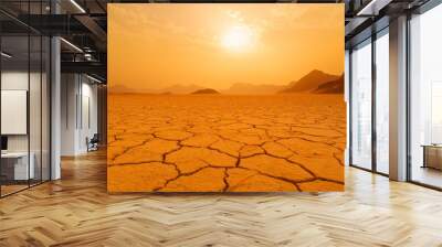 A barren landscape under a golden sunset with cracked earth. Wall mural