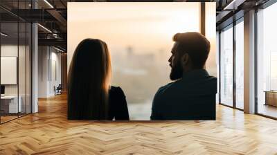 A couple gazes at a sunset, reflecting on their thoughts and emotions. Wall mural