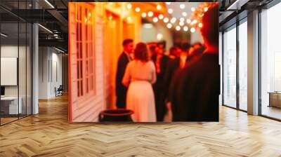 A warm evening gathering with people socializing under string lights. Wall mural