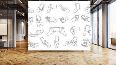 Collection of hands holding modern smartphone drawn with black contour lines. Bundle of outline drawings of palms and phones isolated on white background. Vector illustration in monochrome colors. Wall mural