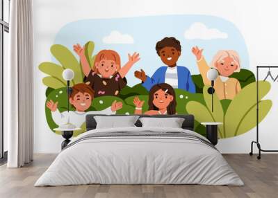 Happy children peeping, hiding behind plants in park. Cute kids group greeting, waving with hand, portrait. Boys, girls playing outdoor in nature. Flat vector illustration isolated on white background Wall mural