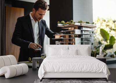 Architectural model with man wearing suit indoors. Wall mural