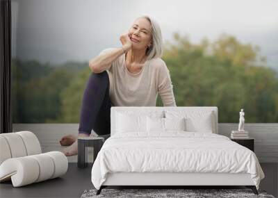  Beautiful elderly woman sitting outdoors in sportswear Wall mural