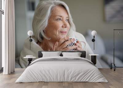  Cosy looking senior woman at home with hot drink Wall mural