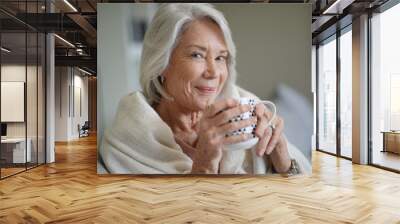  Cosy looking senior woman at home with hot drink Wall mural