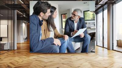    Couple with real-estate agent looking at contract in modern house Wall mural