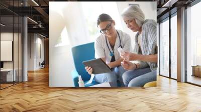  Doctor going through results and medication on tablet with senior patient Wall mural