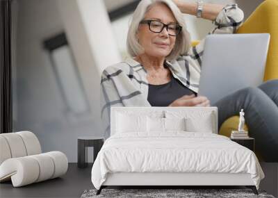  Relaxed modern senior woman at home on computer Wall mural