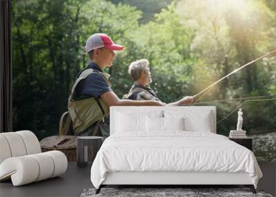 A father and his son fly fishing in summer on a beautiful trout river with clear water Wall mural