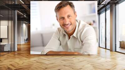 attractive smiling man relaxing at home Wall mural