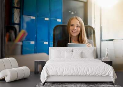 Attractive young woman working on tablet in modern startup office Wall mural