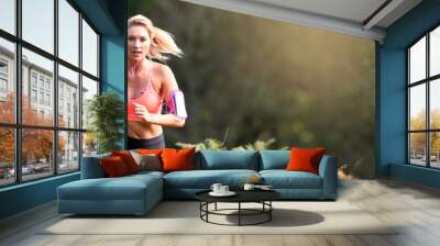 Beautiful athletic woman running in forest Wall mural