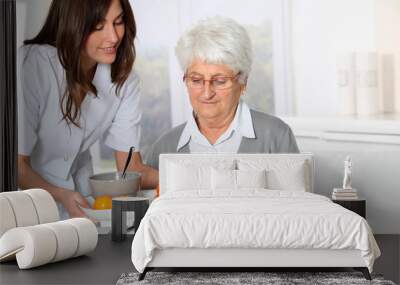 Beautiful nurse bringing meal tray to old woman at nursing home Wall mural