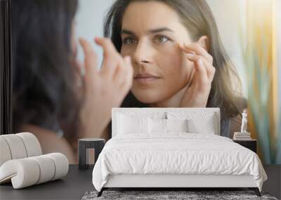 Beautiful woman in front of mirror looking at her face Wall mural