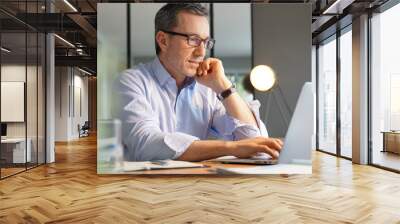 Business manager working in office on laptop Wall mural