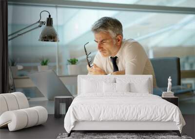 Businessman working on laptop in office, being concerned Wall mural