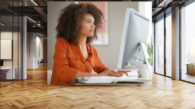 Cheerful businesswoman working on desktop computer Wall mural