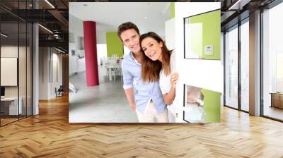 Cheerful couple inviting people to enter in home Wall mural