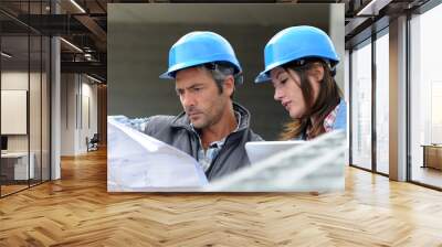 Closeup of engineers reading plan on building site Wall mural